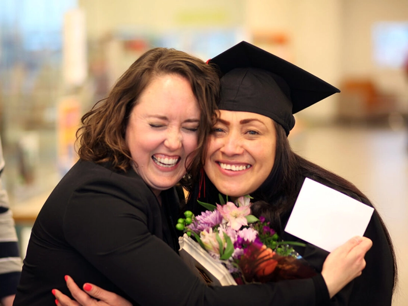 Woman hugging graduate 