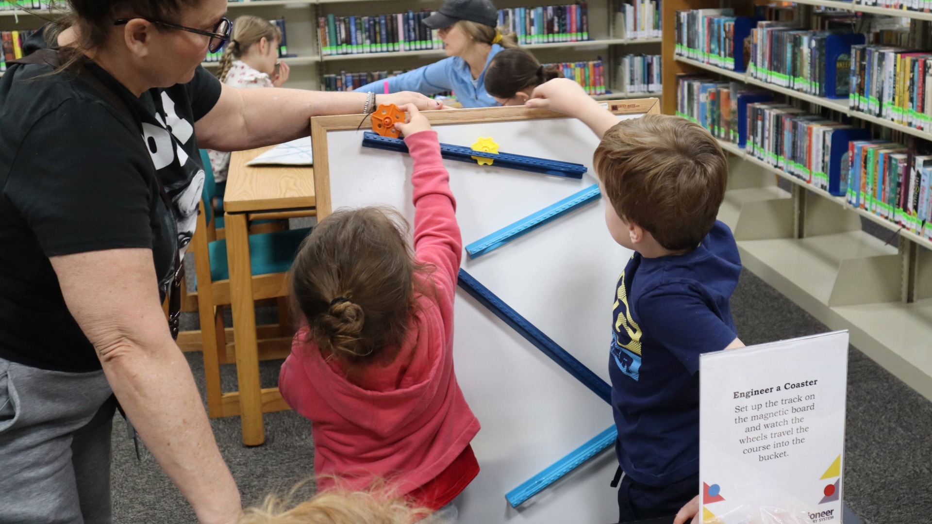 two children work on an engineering challenge at the library